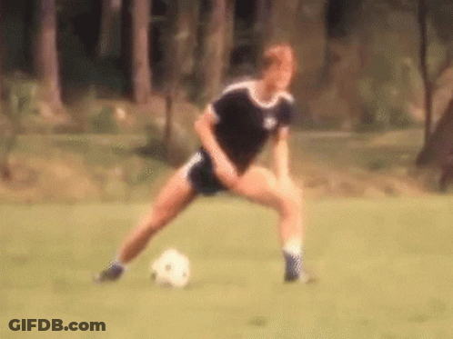 A Blurry Picture Of A Person Kicking A Soccer Ball On A Field GIF