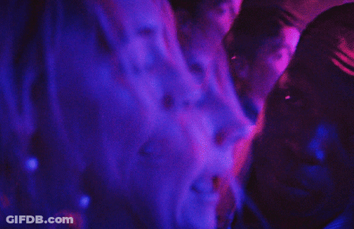 A Blurry Picture Of A Person 'S Back With Purple And Blue Lights Behind Them GIF