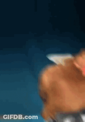 A Blurry Picture Of A Person 'S Face Against A Dark Blue Background GIF