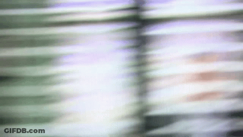 A Blurry Picture Of A Person 'S Face Behind Blinds GIF