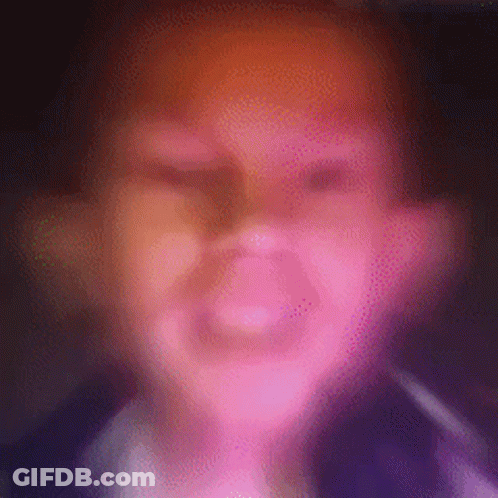 A Blurry Picture Of A Person 'S Face With A Pink And Orange Background . GIF