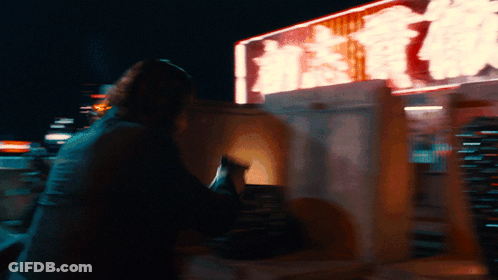 A Blurry Picture Of A Person Sitting In Front Of A Sign That Says ' Hong Kong ' On It GIF