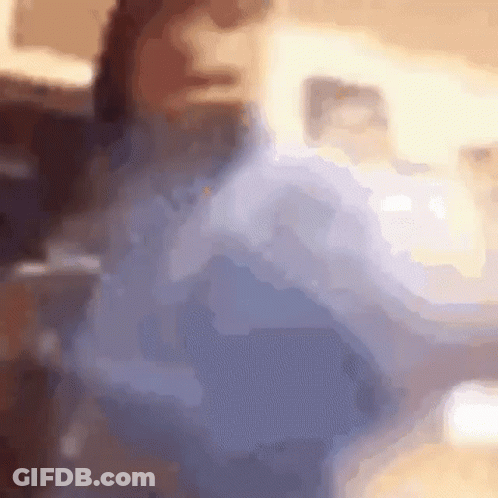 A Blurry Picture Of A Person Sitting On A Couch In A Living Room . GIF