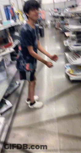 A Blurry Picture Of A Person Standing In A Store Looking At Something GIF