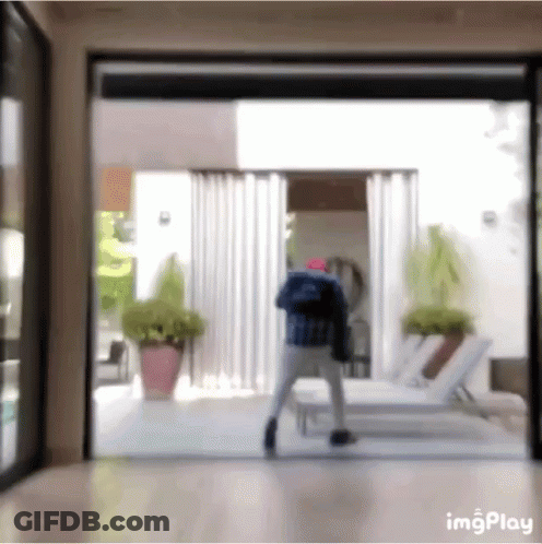 A Blurry Picture Of A Person Standing In Front Of A Sliding Glass Door . GIF