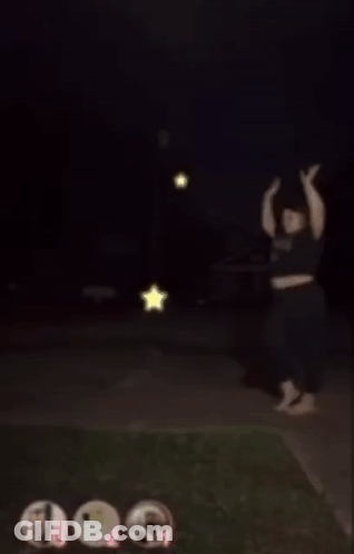 A Blurry Picture Of A Person Standing On A Sidewalk With A Star In The Background GIF
