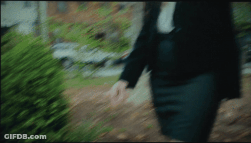 A Blurry Picture Of A Person Walking Down A Sidewalk GIF