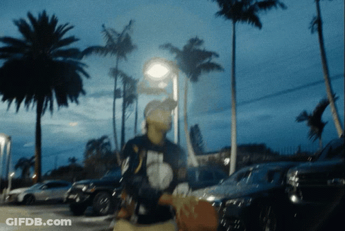 A Blurry Picture Of A Person Walking In A Parking Lot GIF