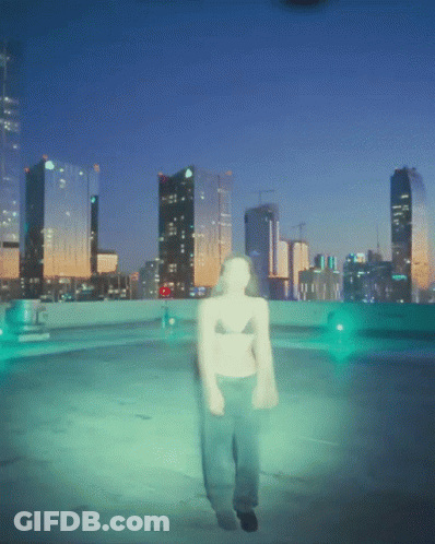 A Blurry Picture Of A Person Walking In Front Of A City Skyline At Night GIF