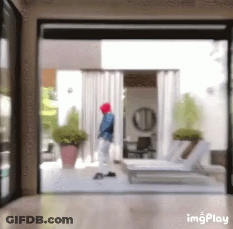 A Blurry Picture Of A Person Walking Through A Sliding Glass Door GIF