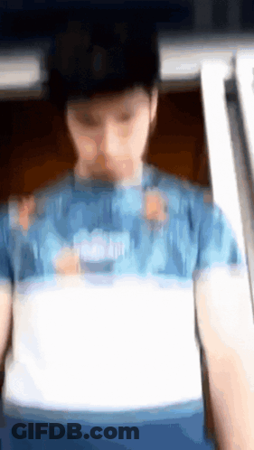 A Blurry Picture Of A Person Wearing A Blue Shirt GIF