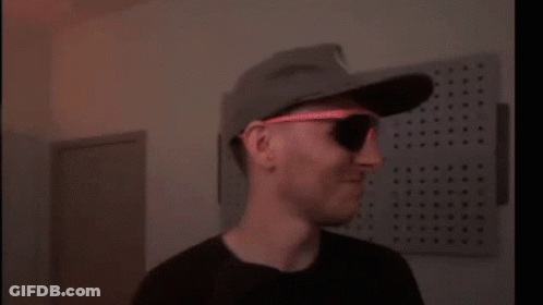 A Blurry Picture Of A Person Wearing A Hat And Sunglasses . GIF