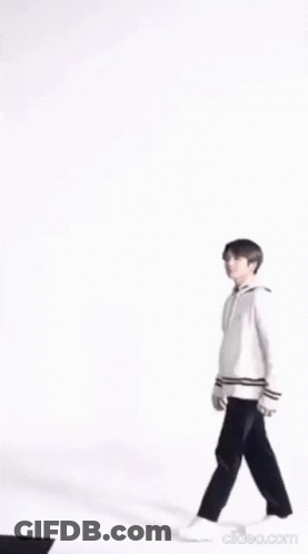 A Blurry Picture Of A Person Wearing A White Jacket And Holding A Purse . GIF