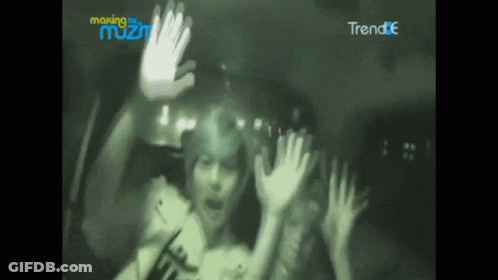 A Blurry Picture Of A Person With Their Hands Up In Front Of A Sign That Says Making The Most GIF