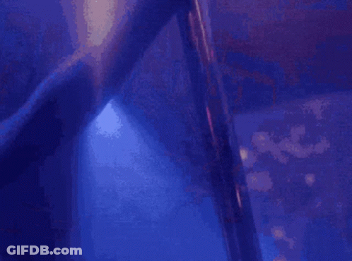 A Blurry Picture Of A Pole Dancer In A Club GIF