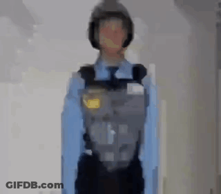 A Blurry Picture Of A Police Officer Wearing A Helmet And A Blue Shirt . GIF