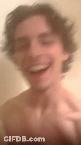 A Blurry Picture Of A Shirtless Man Laughing And Smiling . GIF