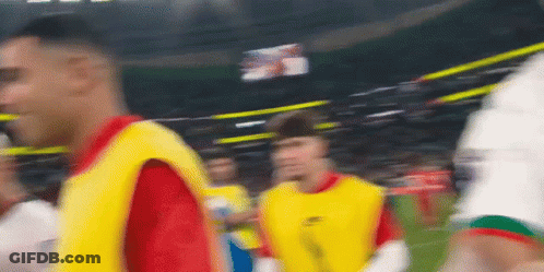 A Blurry Picture Of A Soccer Game With Players In Yellow Vests GIF