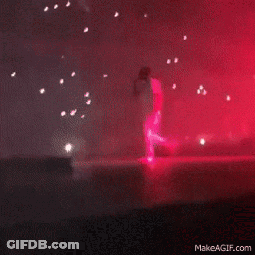 A Blurry Picture Of A Stage With Red Lights Coming Out Of The Ceiling GIF