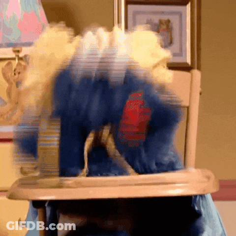 A Blurry Picture Of A Stuffed Animal In A High Chair With A Red Heart On Its Chest GIF