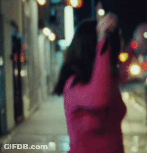 A Blurry Picture Of A Woman In A Pink Sweater GIF