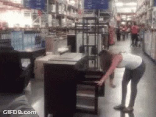 A Blurry Picture Of A Woman In A Store Looking At A Table GIF