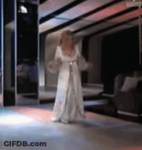 A Blurry Picture Of A Woman In A White Dress With Mbs Written On The Bottom GIF