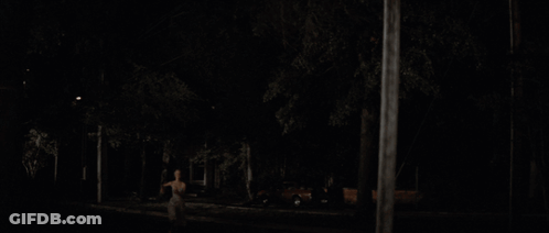A Blurry Picture Of A Woman 'S Back In The Dark GIF