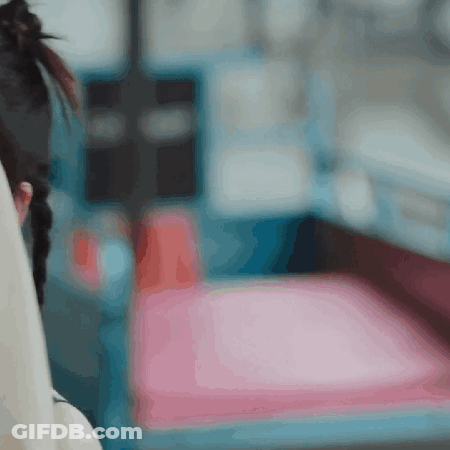 A Blurry Picture Of A Woman Sitting On A Chair GIF