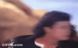 A Blurry Picture Of A Woman Standing In Front Of A Wall . GIF