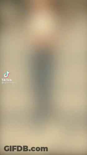 A Blurry Picture Of A Woman Walking Down A Street GIF