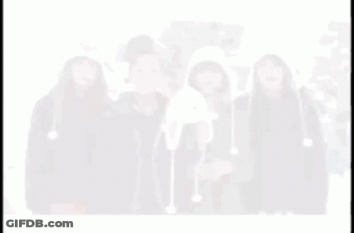 A Blurry Picture Of Four Women Wearing Hats Including One That Looks Like A Penguin GIF