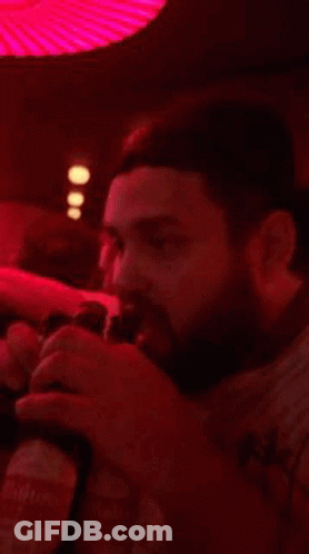 A Blurry Picture Of People Dancing In A Dark Room With Red Lights GIF
