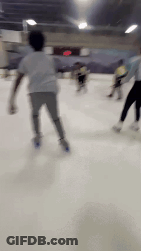A Blurry Picture Of People Ice Skating In A Rink GIF