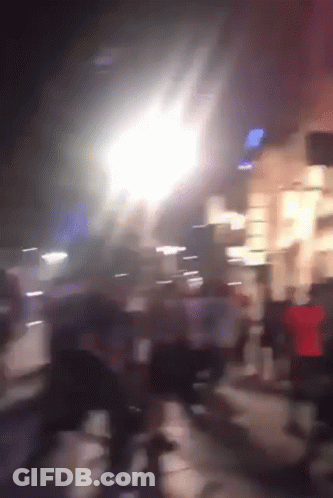 A Blurry Picture Of People Walking Down A Street With A Sign That Says ' Subway ' On It GIF