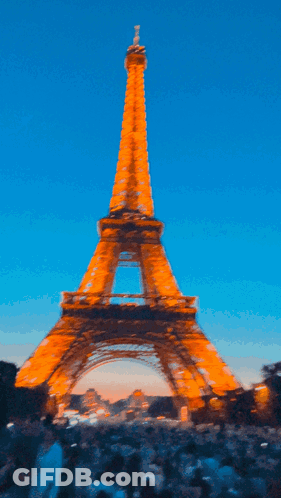 A Blurry Picture Of The Eiffel Tower At Sunset GIF
