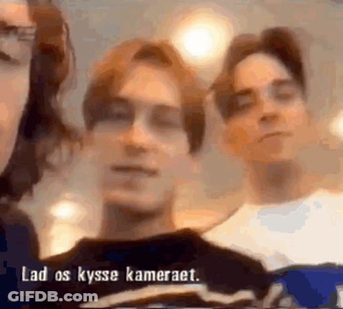 A Blurry Picture Of Three People With The Words " Lad Os Kysse Kameraet " In The Corner GIF