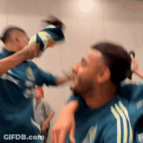 A Blurry Picture Of Two Men Fighting With One Wearing A Blue Adidas Shirt GIF