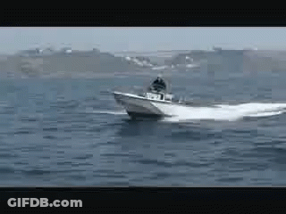 A Boat Is Floating On Top Of A Large Body Of Water GIF