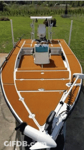 A Boat With A Motor Attached To It Is Parked On A Sidewalk GIF