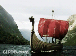 A Boat With A Red Sail Is Floating On A Body Of Water GIF
