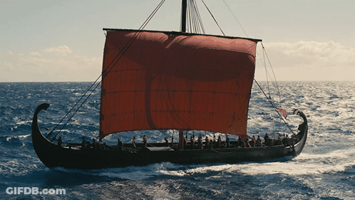 A Boat With A Red Sail Is Floating On The Water GIF