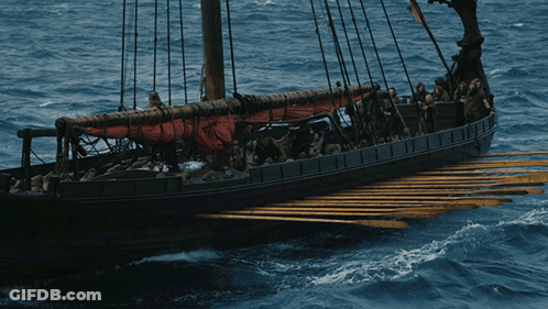 A Boat With A Red Sail Is Floating On The Water GIF