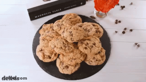 A Book Called Magnolia Table Sits On A Table Next To A Plate Of Cookies GIF