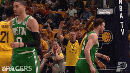 A Boston Celtics Basketball Player Stands In Front Of A Crowd Of Fans GIF