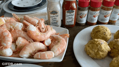 A Bottle Of Cocktail Sauce Sits On A Table Next To A Pile Of Shrimp GIF