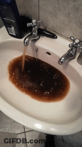 A Bottle Of Dove Shampoo Sits On A Counter Next To A Sink GIF