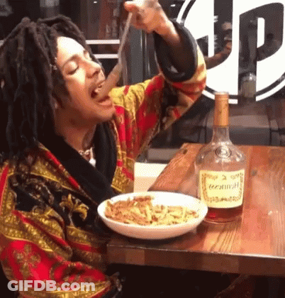 A Bottle Of Hennessy Sits Next To A Plate Of Food GIF