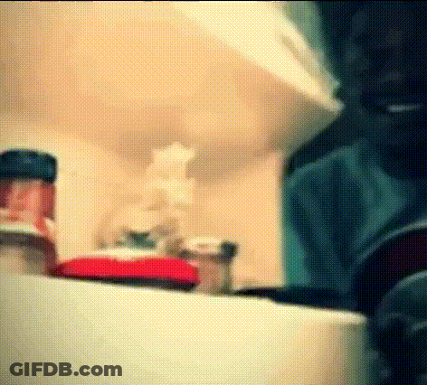 A Bottle Of Ketchup Sits On A Shelf In A Kitchen .. GIF