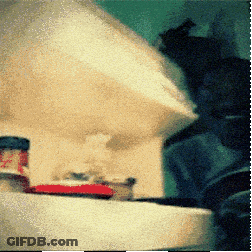 A Bottle Of Ketchup Sits On A Table In A Blurry Picture GIF
